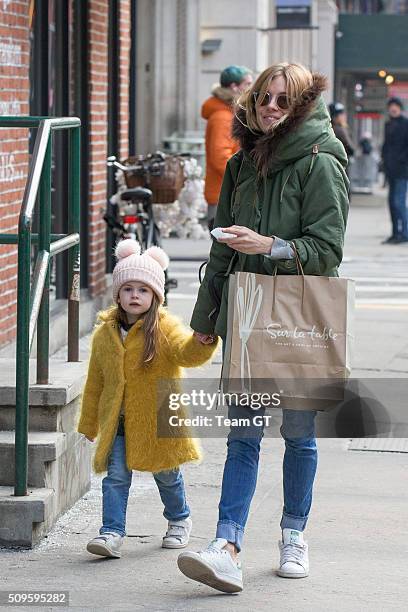 Sienna Miller stopping to get her daughter a cupcake while taking a walk through Soho.