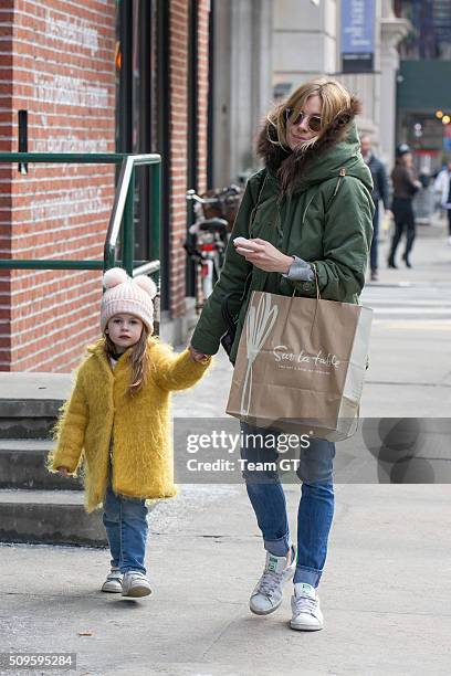 Sienna Miller stopping to get her daughter a cupcake while taking a walk through Soho.