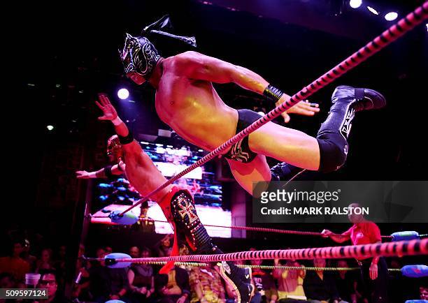 Wrestlers Dragon Lee and Rey Horus leap towards their opponents during the Lucha Va Voom's "Crazy in Love" show at the Mayan Theatre in downtown Los...