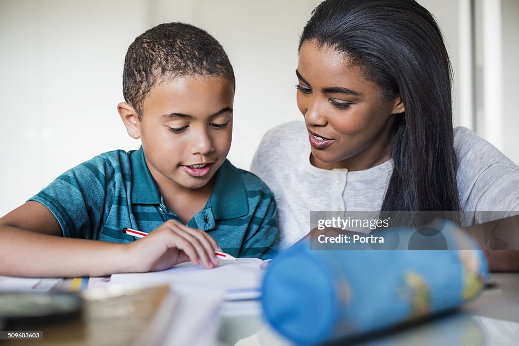 Woman assisting son in doing homework