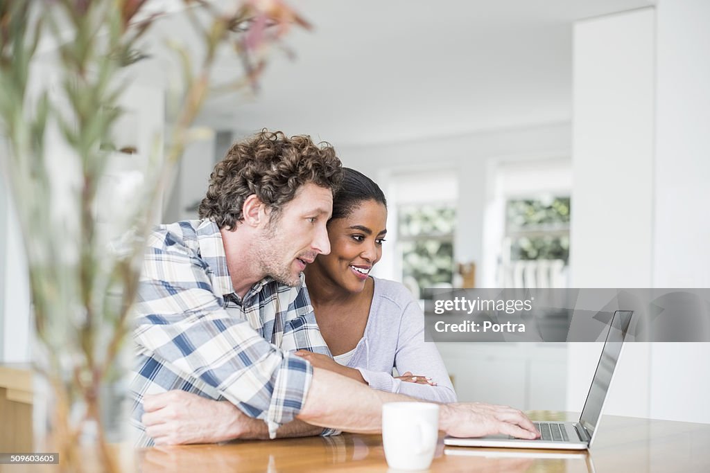 Couple using laptop at home