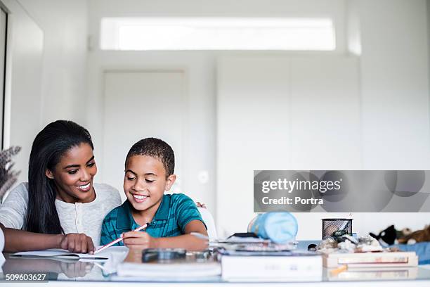 mother assisting son in doing homework - mother child homework stock pictures, royalty-free photos & images