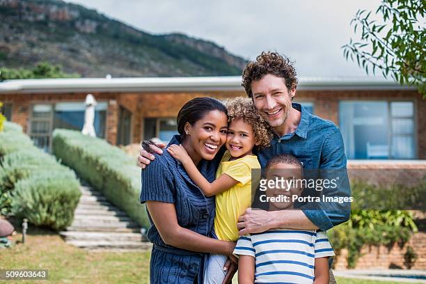 happy multi-ethnic family outside house - multiracial person stock pictures, royalty-free photos & images