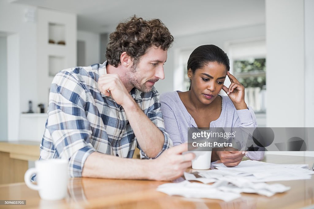 Tensed couple reading bills