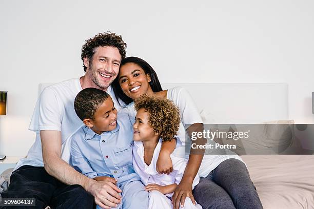 happy parents with children on bed - mixed race person stockfoto's en -beelden