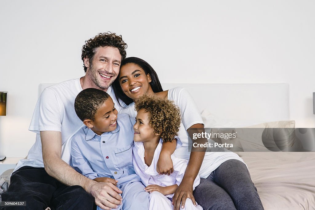 Happy parents with children on bed