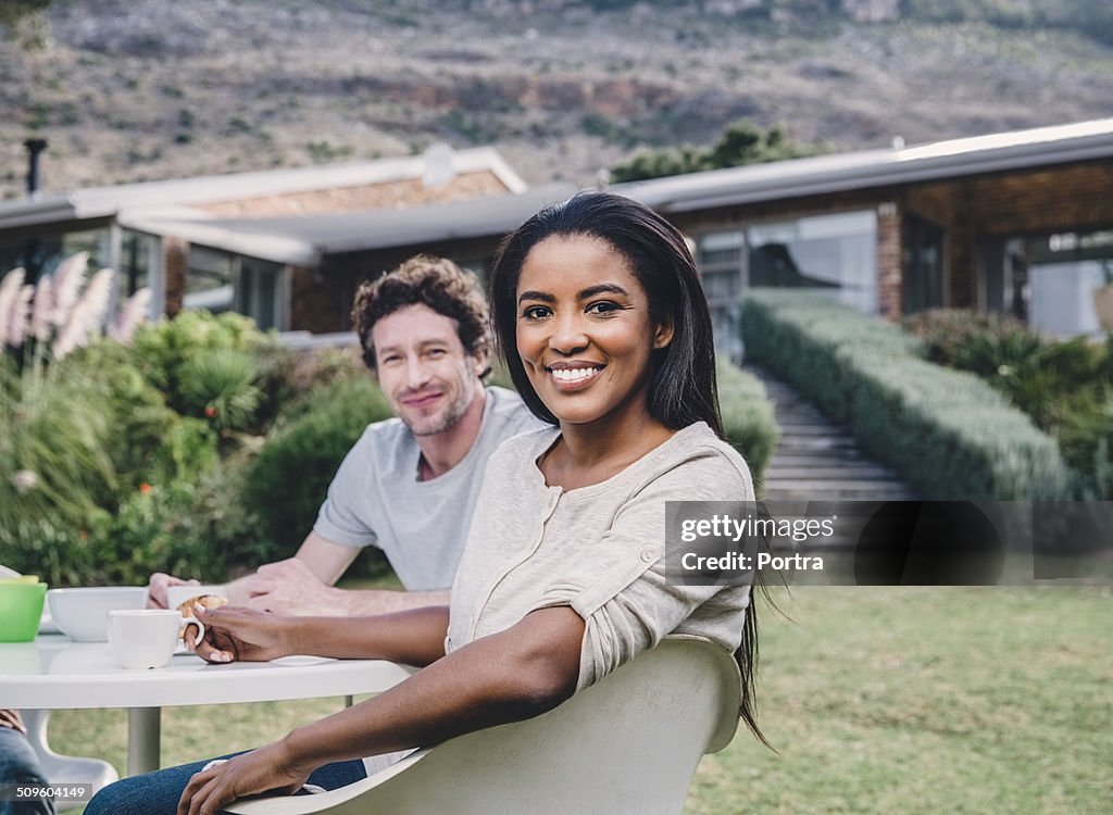 Happy couple having breakfast at yard