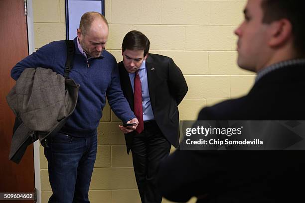 Republican presidential candidate Sen. Marco Rubio and Senior Advisor Todd Harris look at news reports about the campaign on Harris' phone before a...