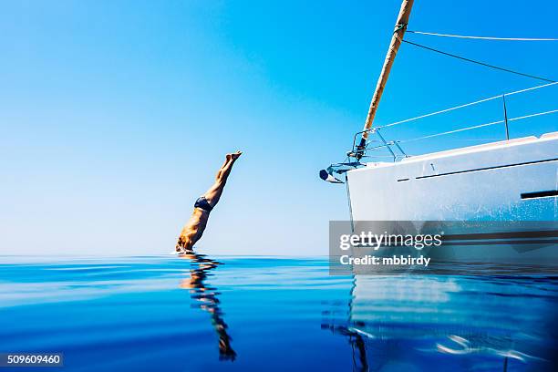 man jumping in sea from sailboat - yachting 個照片及圖片檔