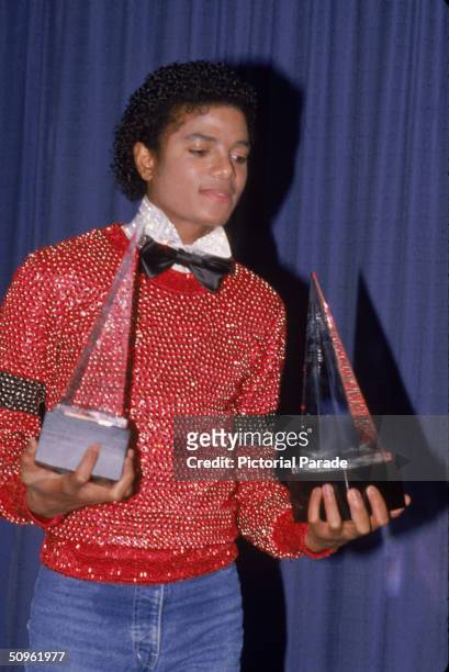 American pop singer Michael Jackson carries the two American Music Awards he won for his album 'Off the Wall,' they are for Favorite Male Vocalist -...