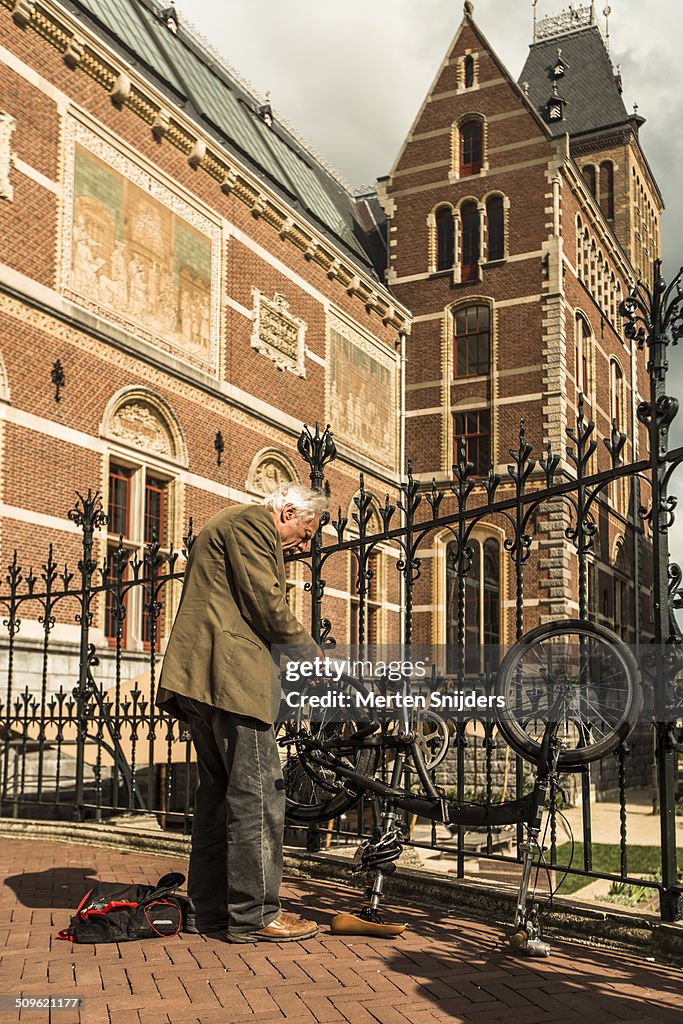 Man repairing flat tire outside Rijksmuseum