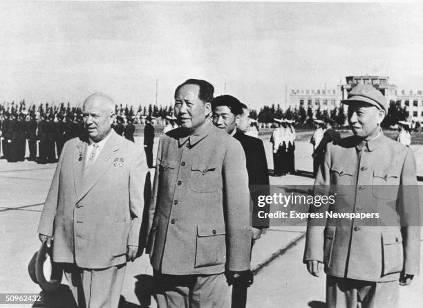 Russian premier Nikita Khrushchev , Chinese Communist leaders Mao Zedong and Liu Shaoqi survey the Chinese troops at Peking Airport , China October...