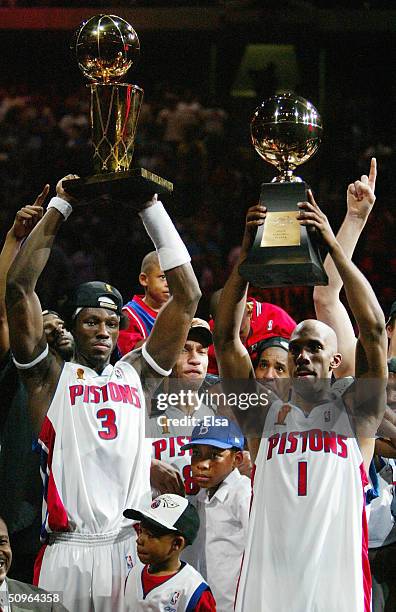 Ben Wallace of the Detroit Pistons holds up the Larry O'Brien NBA Championship as teammate Chauncey Billups holds the MVP trophy after defeating the...