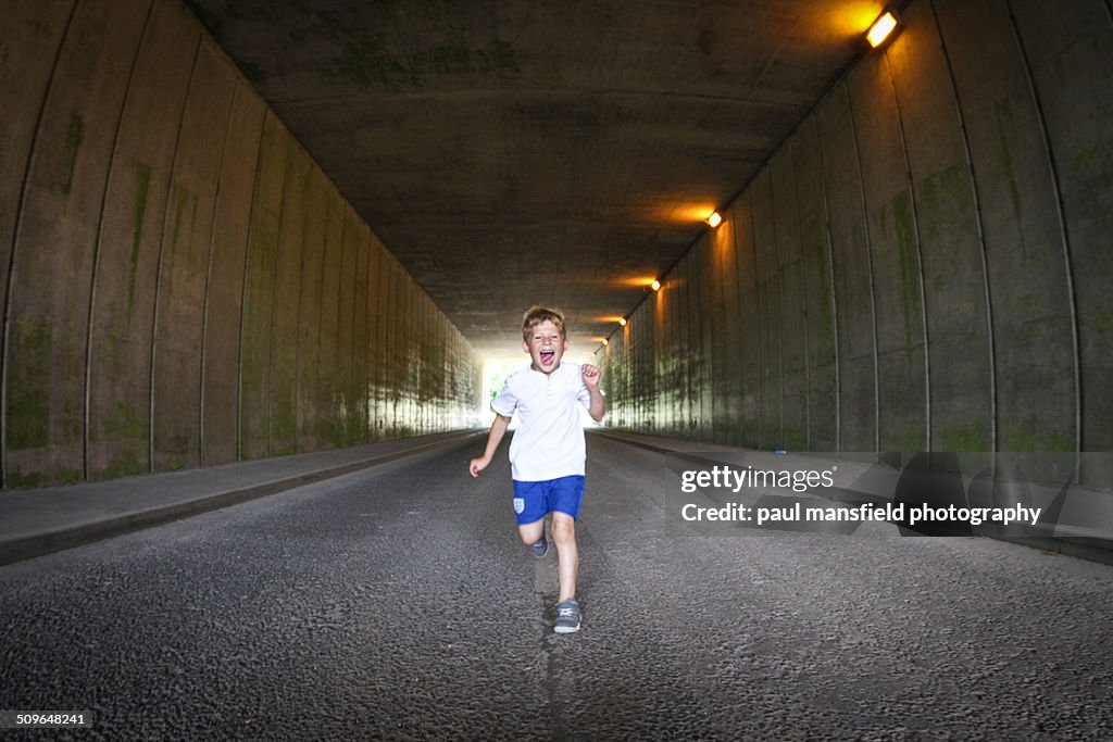 Boy running through tunnel