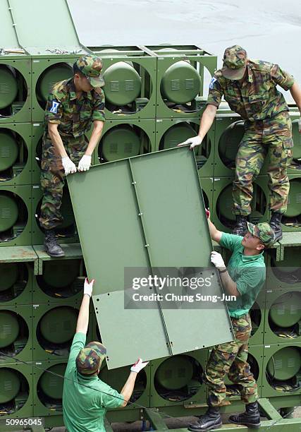 South Korean soldiers disassemble a battery of propaganda loudspeakers on the border with North Korea on 16 June 2004 in Paju, South Korea. The...