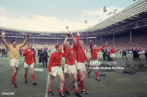 Bobby Charlton raises the Jules Rimet trophy in the air following England's 4-2 victory after extra time over West Germany in the World Cup Final at...