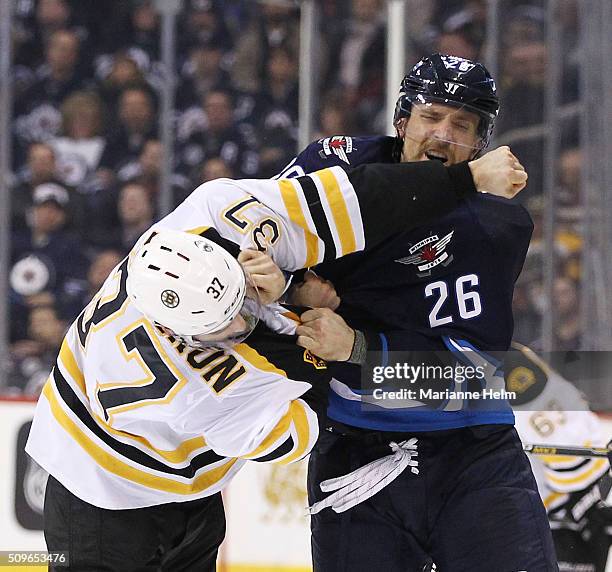 Patrice Bergeron of the Boston Bruins and Blake Wheeler of the Winnipeg Jets fight in second period action in an NHL game at the MTS Centre on...