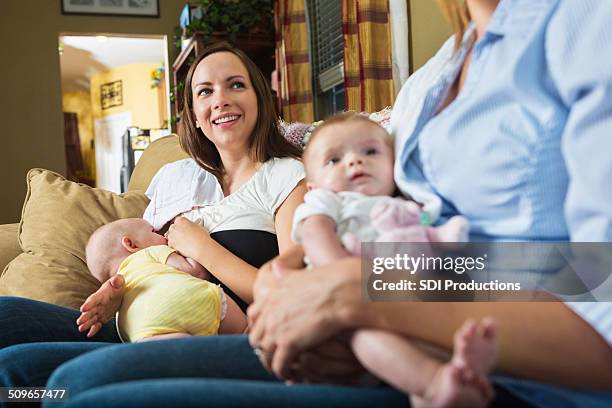 mother with breastfed baby during breastfeeding support group meeting - represented stock pictures, royalty-free photos & images