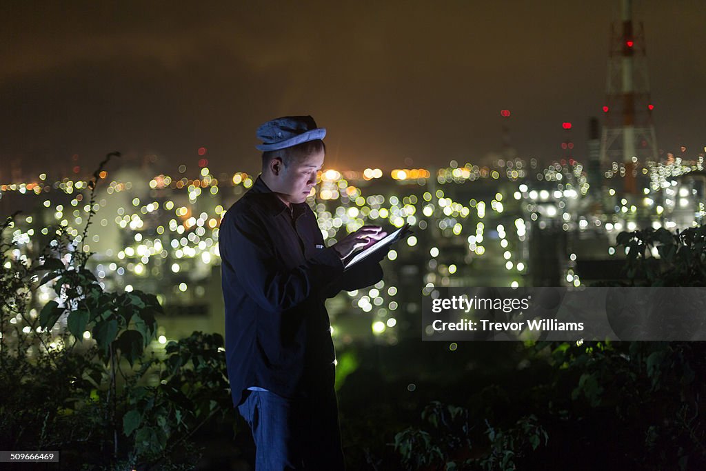 A man using a tablet at night