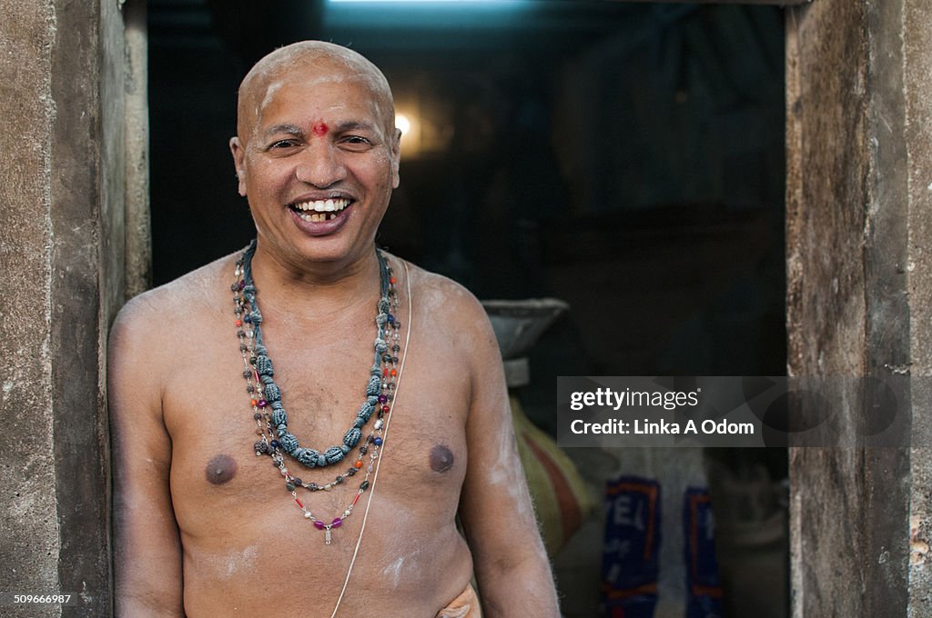 An Indian man smiling in a doorway.