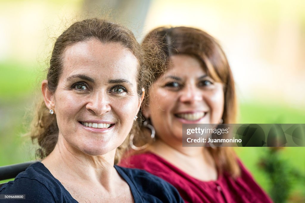 Two middle-aged women posing smiling