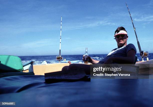 Musician Bob Carpenter of the folk rock Nitty Gritty Dirt Band enjoys a Corona beer break on the rear of a boat while he fishes for Marlin on October...