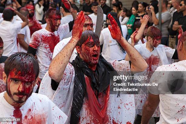 Procession of shi'ite muslim men, carrying swords and knives, covered in their own blood, on the streets of Nabatieh , Lebanon, on the Day of Ashura....