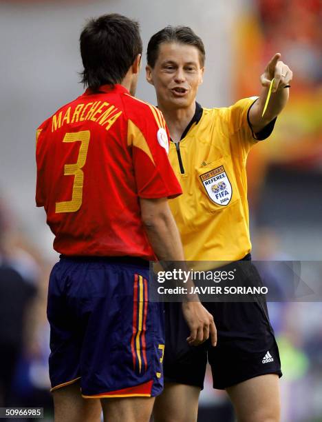 The referee, Slovakia's Lubos Michel gives a yellow card to Spain's defender Carlos Marchena, 16 June 2004 at Bessa stadium in Porto, during the Euro...