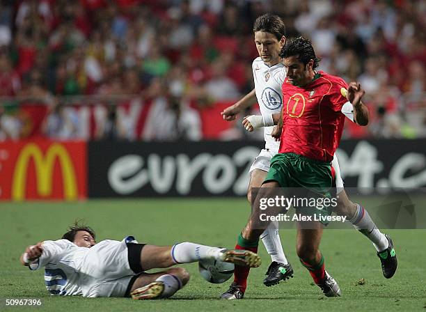Luis Figo of Portugal clashes with Dmitry Loskov of Russia during the UEFA Euro 2004, Group A match between Russia and Portugal at the Luz Stadium on...