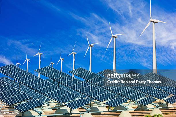 wind turbines and solar panels making green energy - solar farm stockfoto's en -beelden