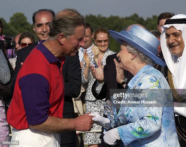 Queen Elizabeth II greets her son Charles the Prince of Wales at a polo match at Windsor Great Park following the second day of Royal Ascot on June...