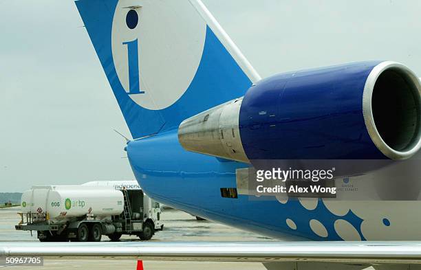 An oil-tanker passes by an Independence Air plane on June 16, 2004 at Dulles Airport in Virginia outside Washington, DC. Low-fare U.S. Carrier...