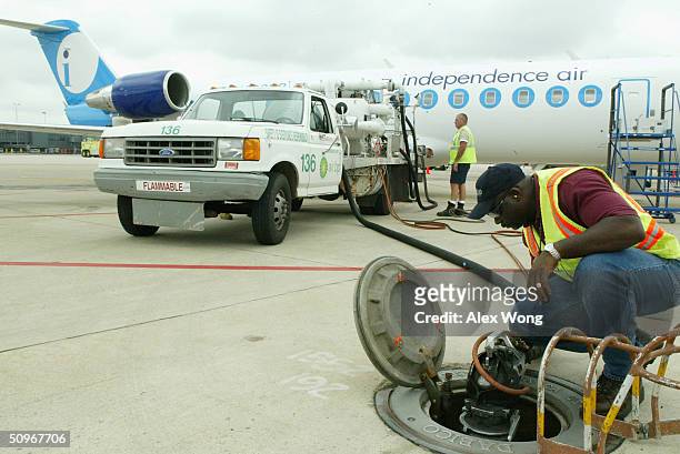 Ground crew members refuel an Independence Air plane on June 16, 2004 at Dulles Airport in Virginia outside Washington, DC. Low-fare U.S. Carrier...