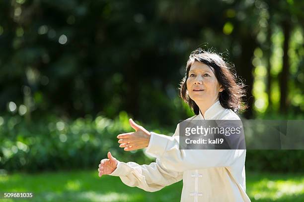 senior woman practicing tai chi - woman and tai chi stock pictures, royalty-free photos & images