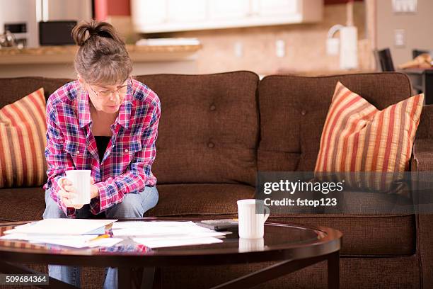 senior adult woman struggles to pay past due bills. home. - dust bildbanksfoton och bilder