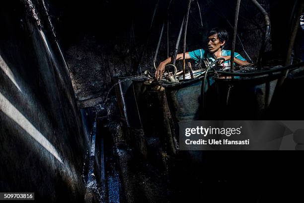 Worker controls the heat of boiler drums during the distillation process ethanol alcohol at Bekonang village on February 9, 2016 in Sukoharjo,...