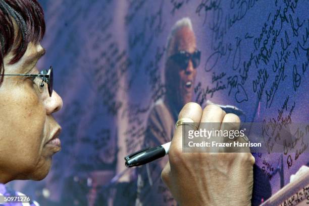 Fan signs a memorial board at the Ray Charles public memorial and viewing held at the Los Angeles Conference Centre June 17, 2004 in Los Angeles,...