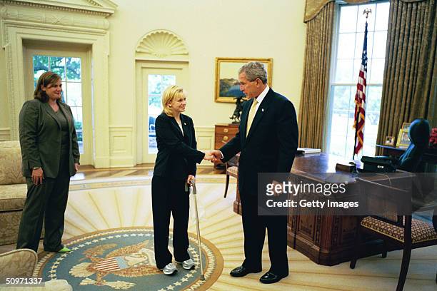 In this handout image provided by the White House, U.S. President George W. Bush meets with Private Jessica Lynch as her friend, Alyssa Gregg watches...