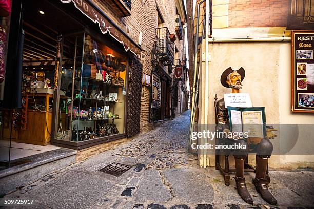 don quixote holding restaurant menu on toledo street, spain - toledo province stock pictures, royalty-free photos & images