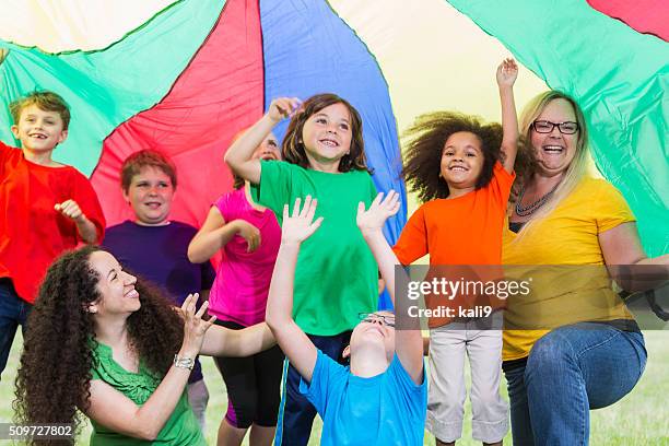 i bambini con consulente in campo colorato di un paracadute - dance teacher foto e immagini stock