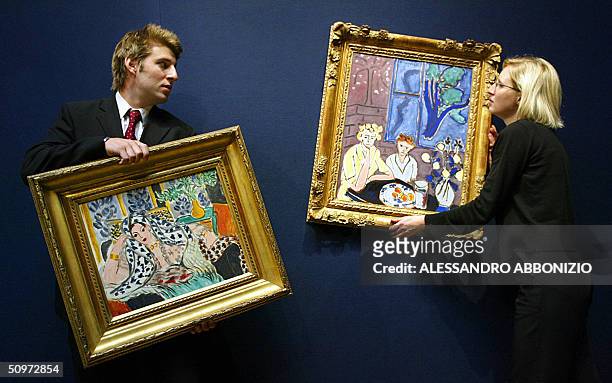 Curators prepare to hang two paintings by Henri Matisse in at Christies in London 18 June 2004. The painting on the left is entitled "Odalisque au...