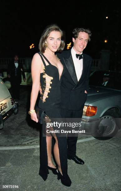 British actor Hugh Grant and his girlfriend Elizabeth Hurley attend the premiere of "Four Weddings And A Funeral" on May 11, 1994 in London, England.