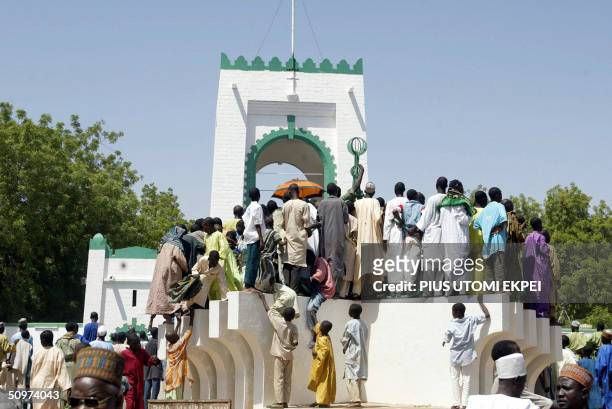 Islamic faithfuls stand on a podium 18 June 2004 to watch activities marking the bicentenary of Sokoto Caliphate at the palace of the Sultan of...