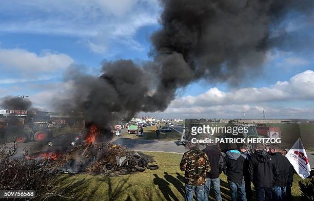 Farmers from the French farmers unions burn piles of tyres in Vendenheim, eastern France on February 12 protesting their increasing constraints and...