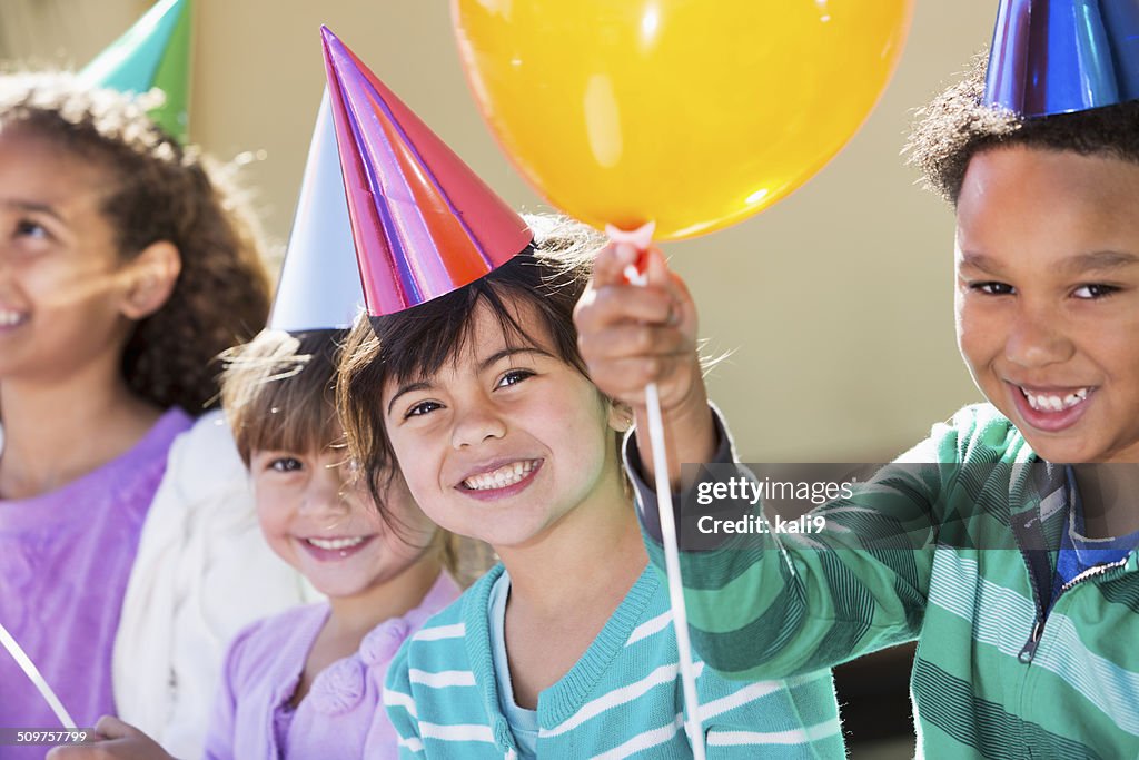 Bambini alla festa di compleanno e palloncini con cappelli