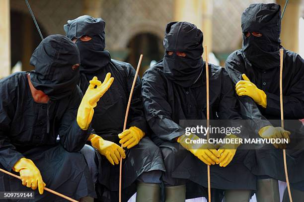 Indonesian Sharia policemen look on during a public caning punishment of 36 men at a Mosque in Meulaboh on the west coast of Aceh province on...