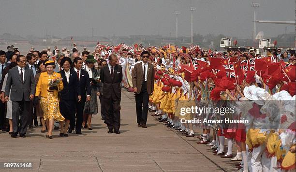 Queen Elizabeth ll and Prince Philip, Duke of Edinburgh are welcomed by by flag waving children as they arrive in Shanghai during their tour of China...