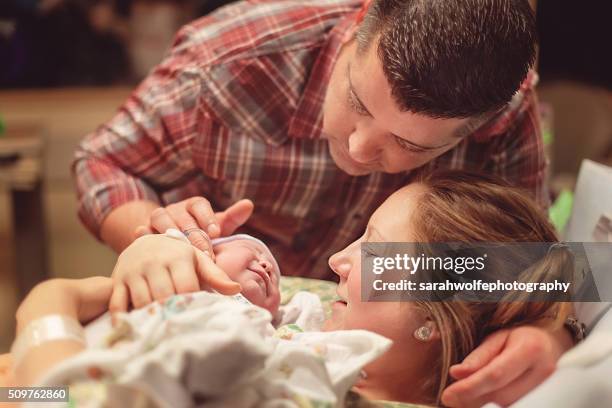 couple looking at their newborn baby for the first time - delivery room stock pictures, royalty-free photos & images