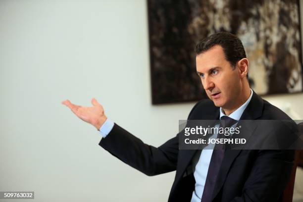 Syrian President Bashar al-Assad gestures during an exclusive interview with AFP in the capital Damascus on February 11, 2016.