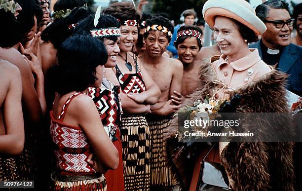 Queen Elizabeth ll, wearing a traditional Maori feather cloak, smiles as she is welcomed by Maoris during her Silver Jubilee Tour of New Zealand on...